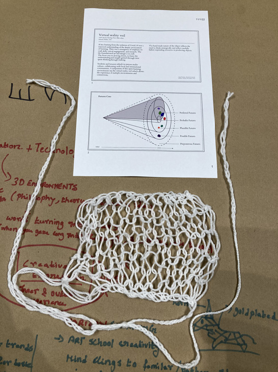 <p><strong>FAST45 Futures Archive – Artefact #15 – <em>Virtual Reality Veil</em></strong></p><p><em>A global pandemic highlighted the social aspect of learning, leading to a revival of craft skills, critical thinking, and research in art and design education. Emphasis shifted to slowing down and fostering understanding through hands-on creation. Students and educators rebuilt studio culture, engaging with local and global communities, facilitated by tools like the virtual reality veil for diverse experiences. The handmade nature of the artefact promotes thoughtful resource use through strategic thinking and reflection in object creation.</em></p>